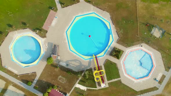 Aerial view of empty pools with slides in abandoned aqua park.