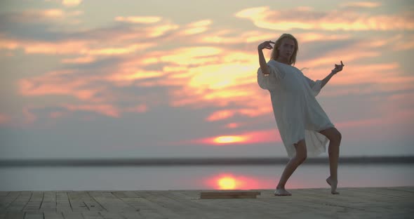 Sexy Dance on the Pier of a Lake During Sunset Woman in White Dress