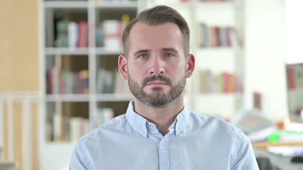 Portrait of Serious Young Man Looking at the Camera