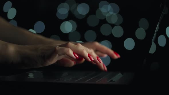 Female Hands is Typing on a Laptop at Night