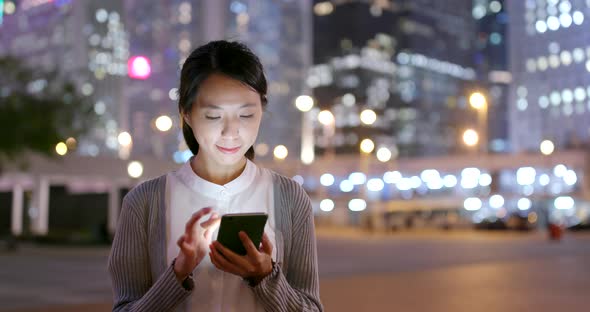 Asian Business woman use of mobile phone in city at night