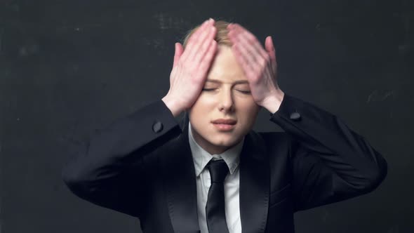 businesswoman in a classic business suit holding head