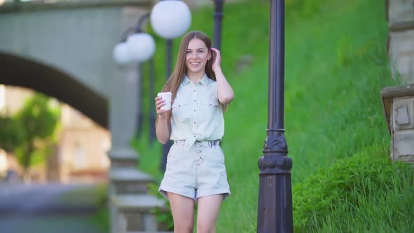 Beautiful Girl in Shorts and a Plastic Cup