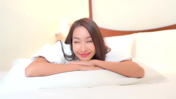 Asian woman relax on bed in bedroom interior