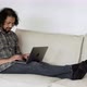 An Indian Freelancer Works at a Laptop At Home, Lies on A Sofa in A Bright Room, Creates A New - VideoHive Item for Sale