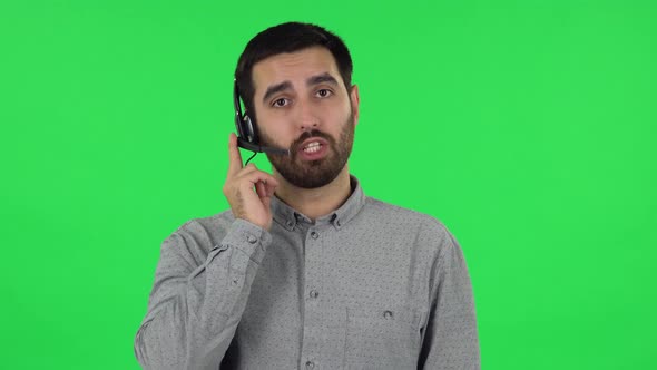 Portrait of Brunette Guy with Headset Helping with Customer Service. Green Screen