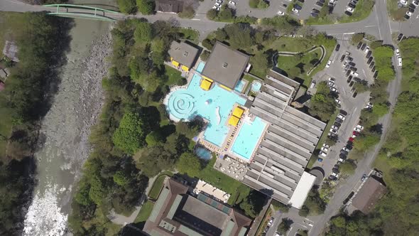 Aerial shot over a day spa resort and large blue bath pool in Lavey les Bains, Switzerland.