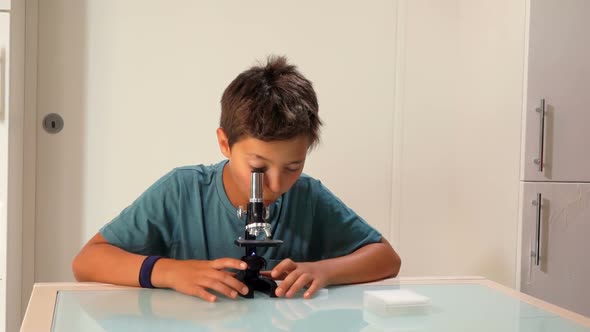 Boy Is Studying a Microscope Slide