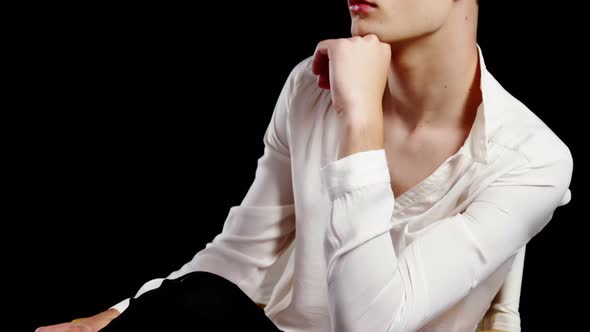 Androgynous man posing against black background