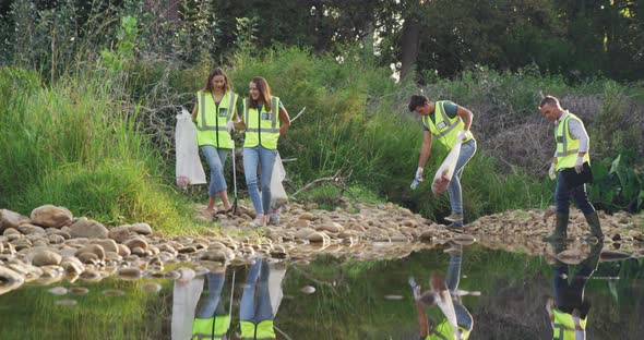 Mid adult with yellow vest volunteering during river clean-up day