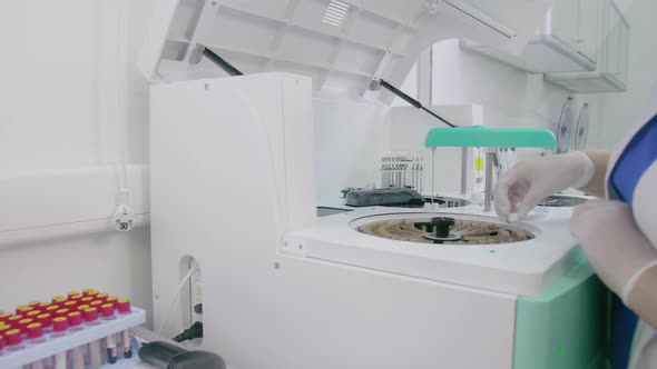 The Medic Places The Tubes With Blood Samples in the biochemical analyzer.