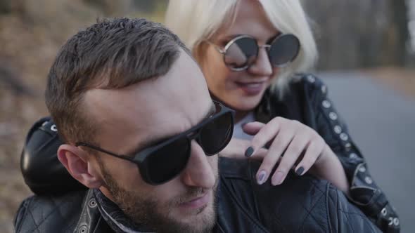 Portrait of Happy Biker's Couple Sitting in Embraces on Motorcycle and Smiling