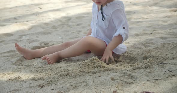 Carefree Baby Boy Builds a House From Sand Child Plays By the Sea