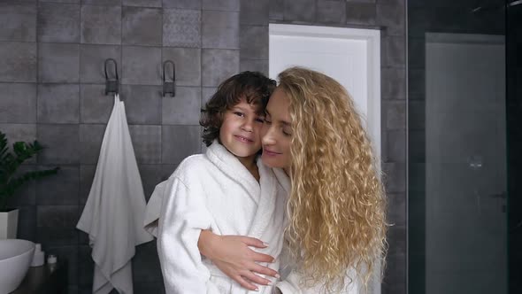 Smiling Happy Mother and Son in Dressing Gowns which Looking at Camera in the Bathroom