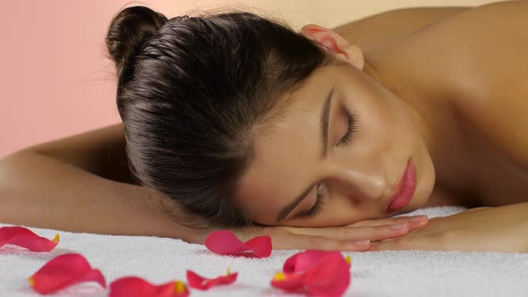 Woman Sleeps and Rest After Spa Treatments on Rose Petals