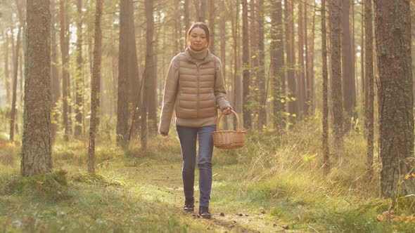 Young Woman Picking Mushrooms in Autumn Forest