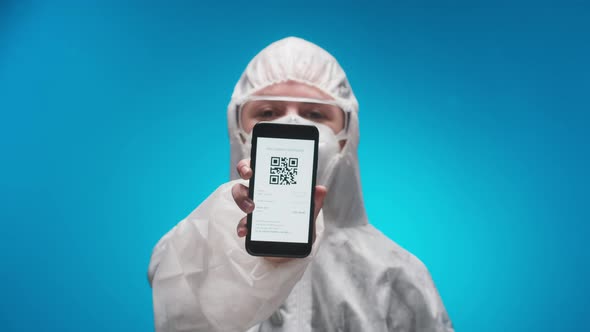 Woman Doctor Wearing Protective Uniform Showing on Phone Vaccination Passport with Qr Code