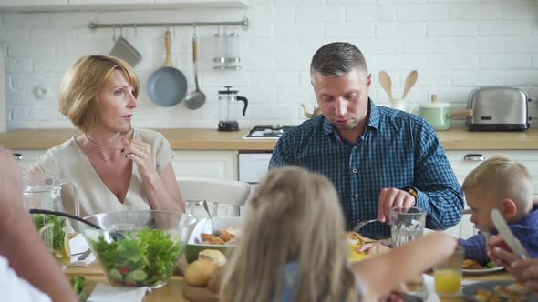 American Caucasian Family with Children Dining Together Sitting at Table in Home Interior