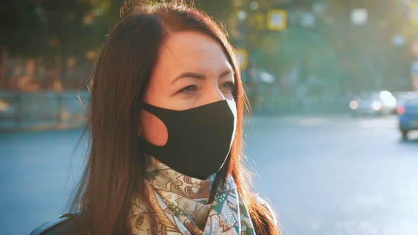 Young Woman in a Medical Mask for Protection From the Epidemic on the Street in the City