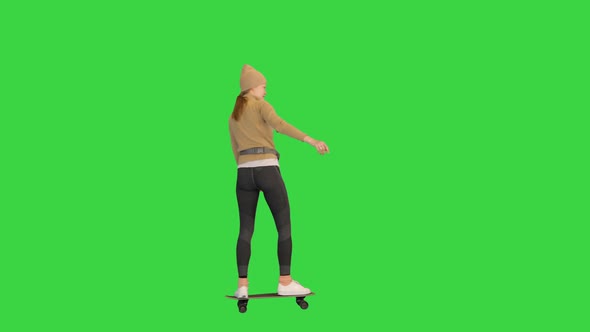 Sporty Woman in Warm Clothes Skateboarding By on a Green Screen Chroma Key