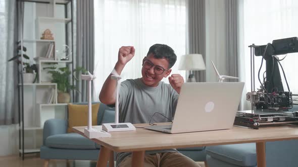 Success Kid Or Student With Laptop Computer Programming Electric Wind Turbine Model At Home