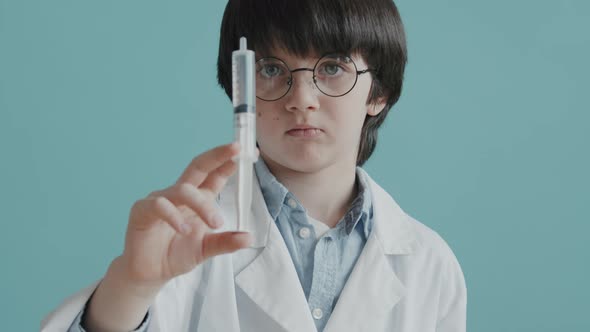 Portrait of Boy in Doctor Costume Holding Syringe