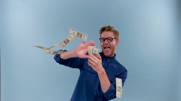 Funny Man Scatters Money Isolated on a Blue Background