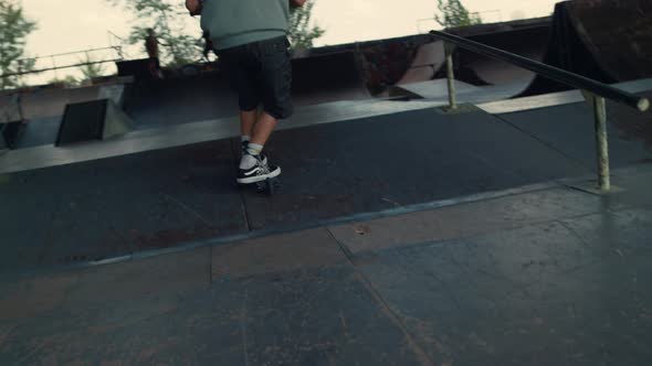 Extreme Boy Jumping with Scooter on Ramp at City Skate Park