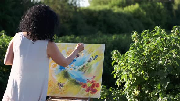 Female Artist Painting a Colorful Painting Outdoors