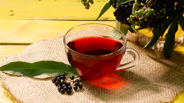 Red Tea From Fresh Black Berries In A Cup Top View On A Wooden Vintage Table. Elderberry Tea.