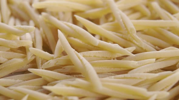 Italian uncooked dry trofie pasta falling in slow motion. Rotation. Macro