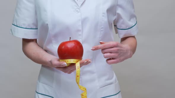 Nutritionist Doctor Healthy Lifestyle Concept - Holding Organic Red Apple and Measuring Tape