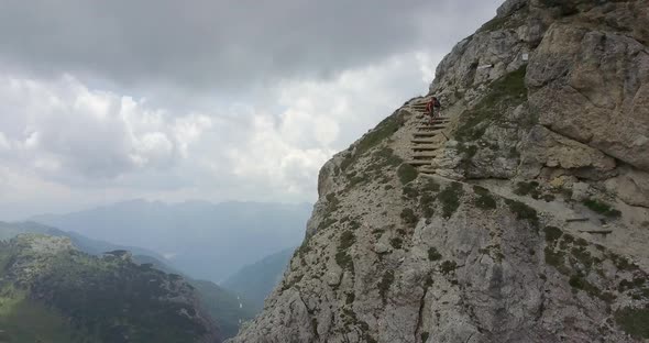 Aerial drone view of a man and woman couple hiking in the mountains.