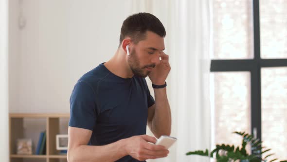 Man with Wireless Earphones Exercising at Home 