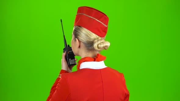 Stewardess Speaks on the Walkie Talkie. Green Screen. Back View
