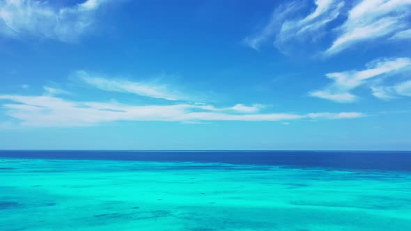 Wide aerial tourism shot of a white sand paradise beach and turquoise sea background in 4K