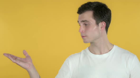 Man Showing Product on Side, Yellow Background