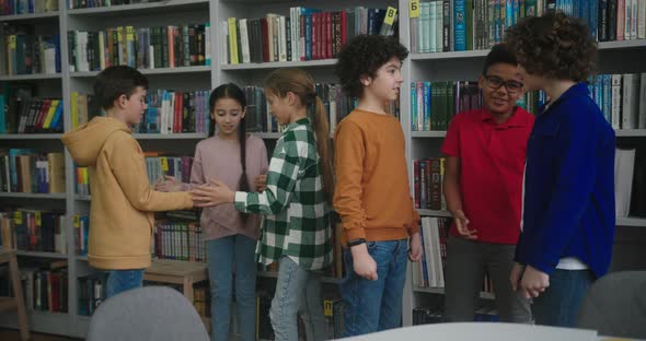 Kids Play Fun Game Near Boys Talking in School Library