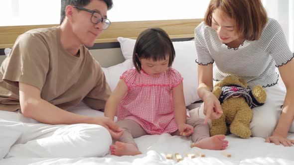 Happy family with mother, father and disabled daughter spending time together at home.