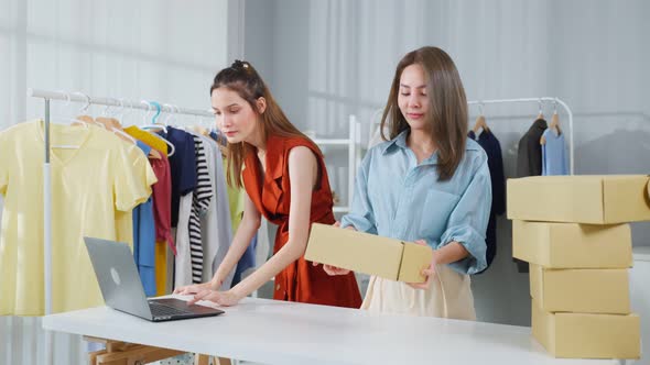 Asian two young businesswoman checking sale order on computer together.