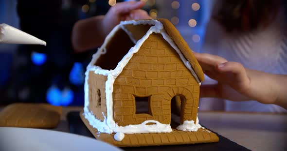 Woman Decorate Gingerbread House