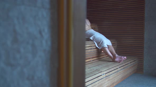 A man relaxes in a sauna at a luxury resort.