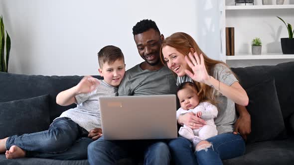 A Happy Multiracial Family of Four with a Laptop