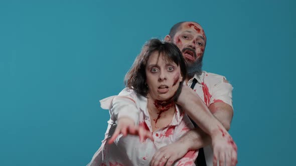 Dangerous Evil Office Zombies Stretching Arms to Camera While Standing on Blue Background