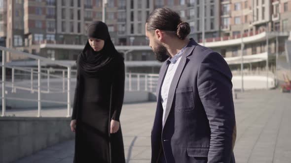 Middle Shot of Furious Middle Eastern Man Looking at Stressed Muslim Woman in Hijab 