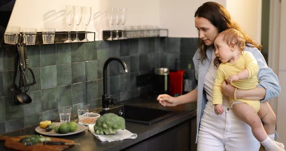 Woman Busy with Household Chores While Nursing Her Baby