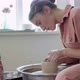 Female Potter Sitting and Makes a Cup on the Pottery Wheel. Woman Making Ceramic Item. Pottery - VideoHive Item for Sale