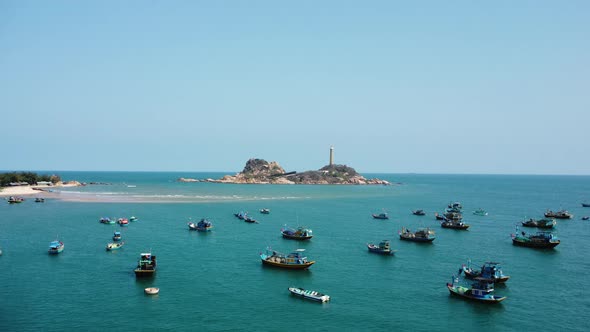 Traditional Boats Floating In The Sea With Ke Ga Lighthouse In The Background In Binh Thuan, Vietnam