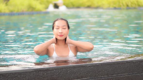 Young asian woman enjoy around outdoor swimming pool for leisure