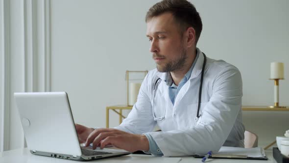 Doctor Using Laptop in Medical Office